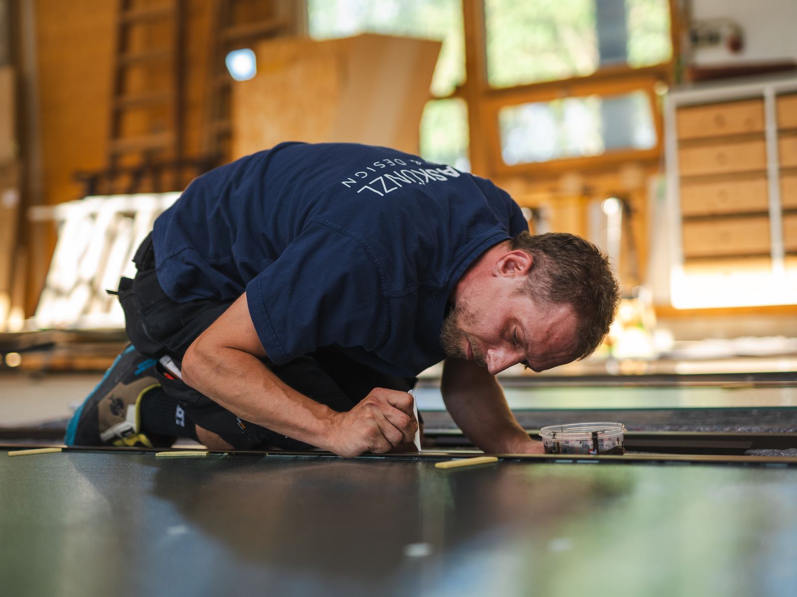 Mitarbeiter von GLAS KÜNZL zeichnet in der Werkstatt auf der Werkbank an